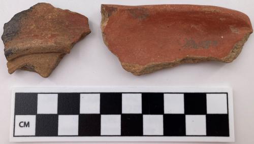 Color photo, 2 red filmed Indigenous ceramic fragments, 1 is a rim fragment with rounded lips.